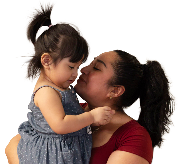 A mother and daughter embracing and smiling at each other outside their home