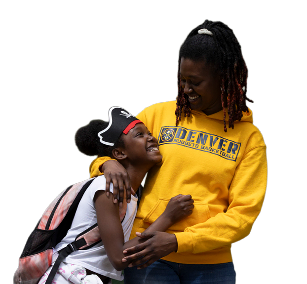 A mother and daughter embracing and smiling at each other outside their home